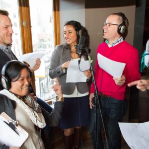 Group of diverse people in a studio space singing together