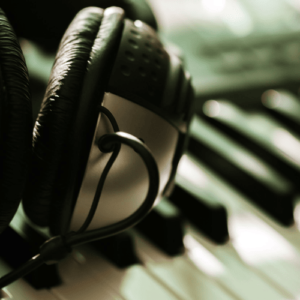 Headphone earpiece on top of a keyboard | Improve Communication Through Arts & Music