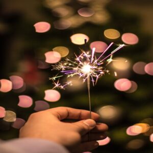 Hand holding a sparkler to celebrate an event | Office Holiday Party