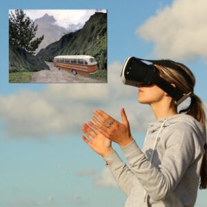 Woman wearing a VR headset seeing the view of a bus driving downhill a road surrounded by mountains