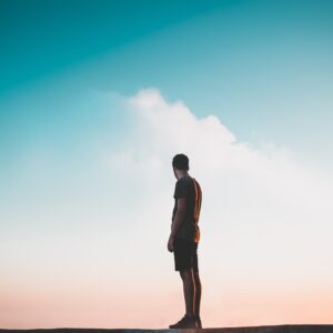 Silhoutte of a man standing with a view of the beuatiful sky and sunset | How to Tap into Your Courage
