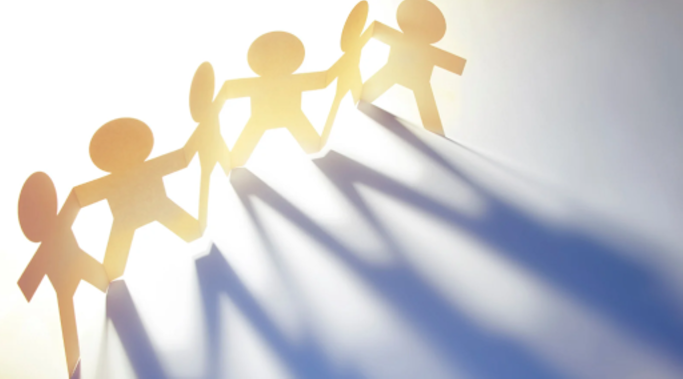 Paper chain of people holding hands with long blue shadows symbolizing teamwork, connection, and adaptability