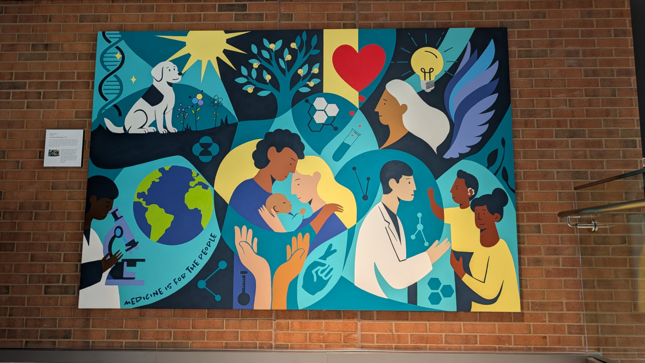 Une murale colorée installée sur un mur de brique au siège des Laboratoires de recherche Merck, représentant des scientifiques, des familles et des patients unis par l’art. L’œuvre symbolise l’espoir, l’innovation et le message « La médecine est pour les gens ».