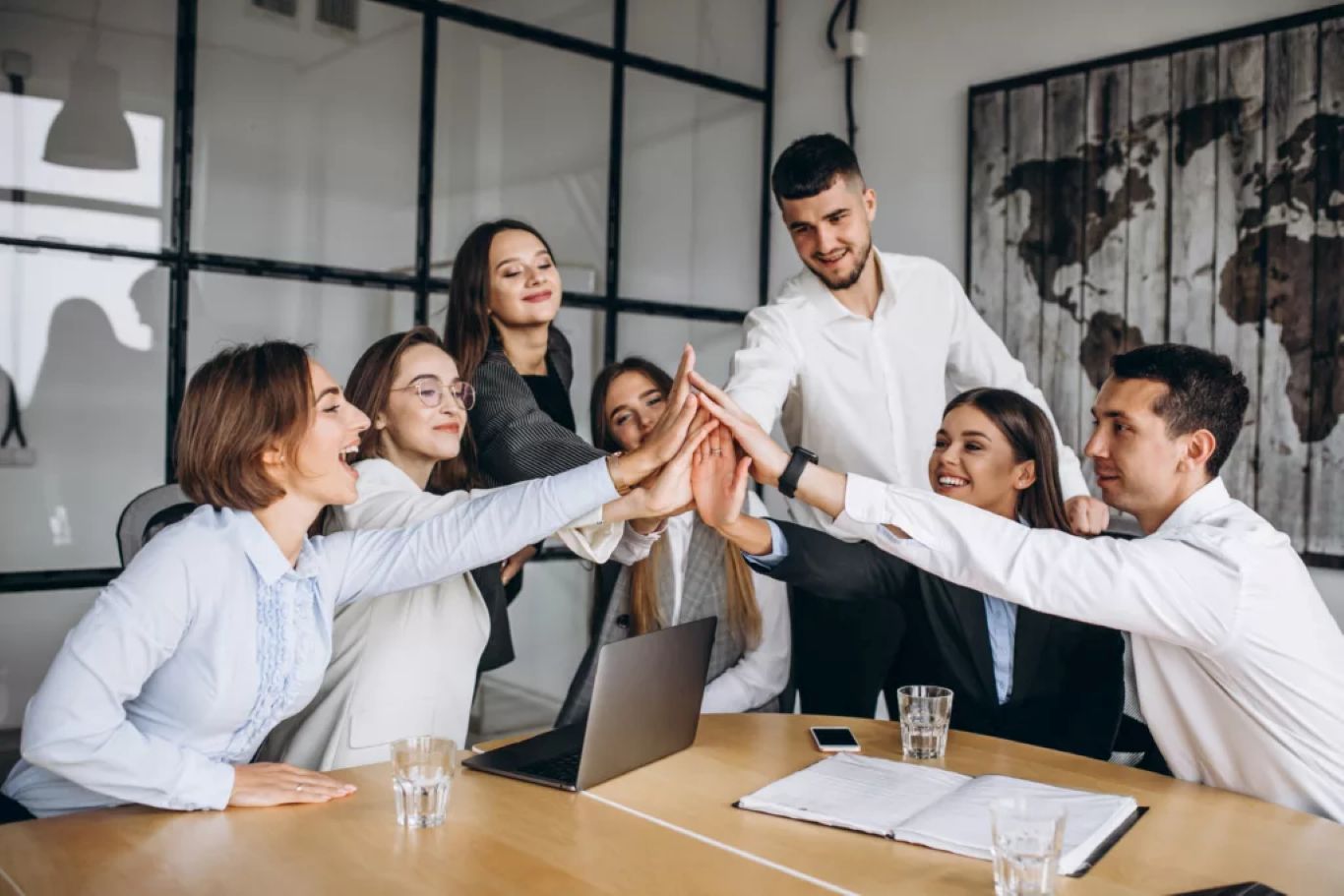 Business team celebrating collaboration success with hands stacked together, symbolizing restored energy, alignment, and team momentum at work.