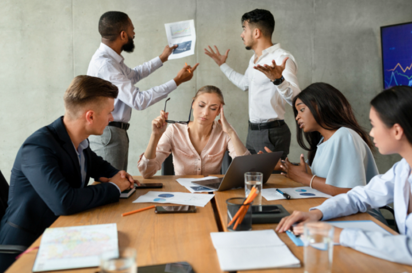 Stressed leadership team in a tense meeting under pressure, showing cognitive overload, reactive communication, and decision fatigue in a high-stakes business environment.
