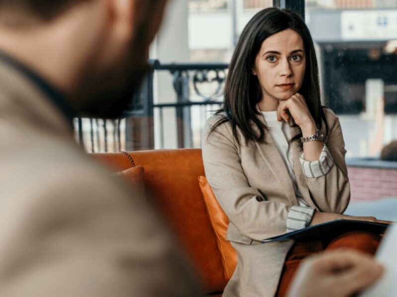 Cadre concentré en discussion de leadership, démontrant de la clarté, du calme et une prise de décision ancrée sans chercher l’approbation.