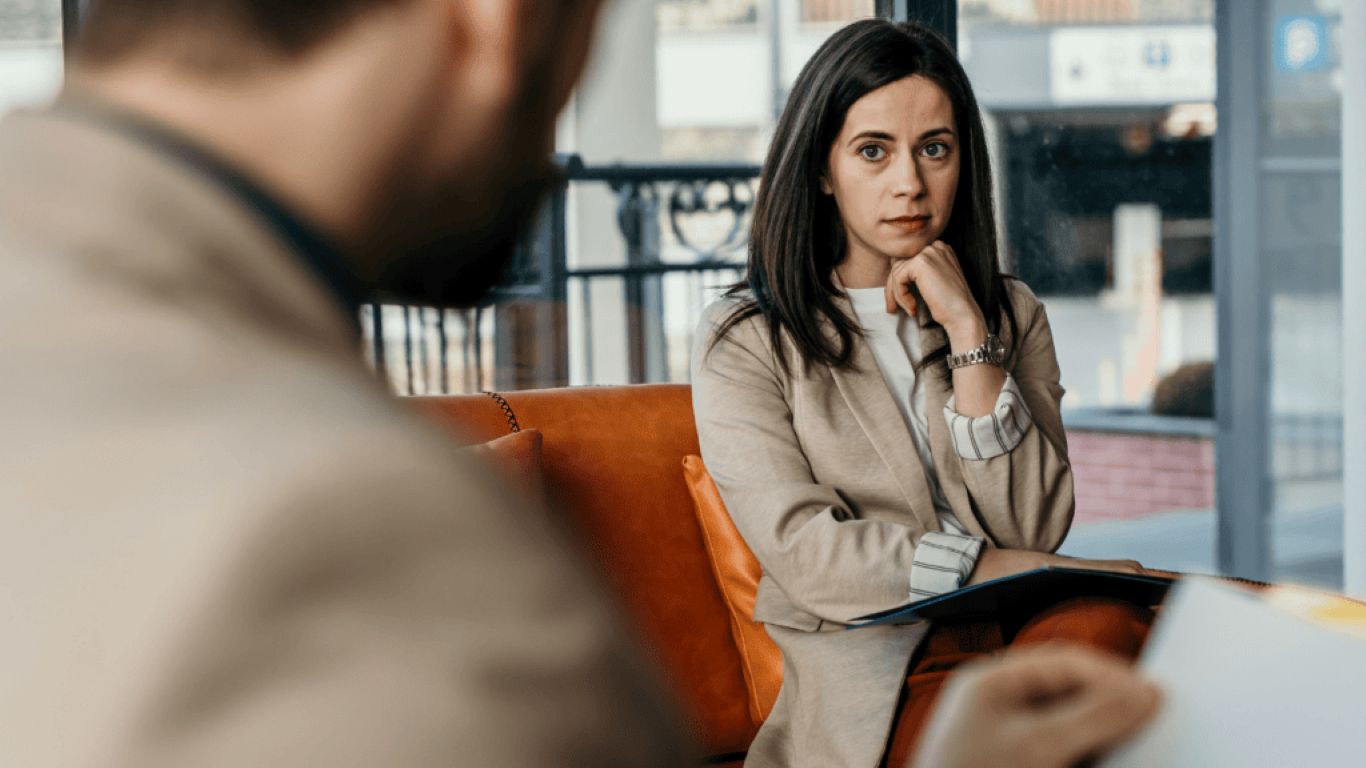 Cadre concentré en discussion de leadership, démontrant de la clarté, du calme et une prise de décision ancrée sans chercher l’approbation.